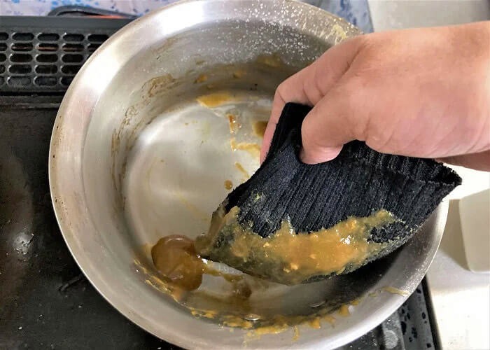 ステンレス製カレー鍋をウエスで拭き取る