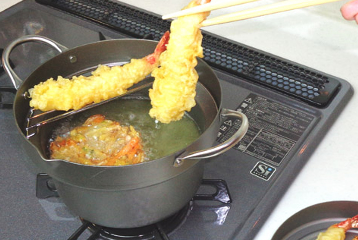 <p><strong>油の飛び散りにくい天ぷら鍋</strong><br />
鍋の中ほどに段がついた深型形状で油が飛び散りにくくなっています。コンパクトなサイズで、少ない油で揚げたいときやお弁当のおかず作りに便利。引き上げた天ぷらは揚げアミの上に置いて油切りができます。付属のフタは裏返すと油切りの皿として使えます。</p>
