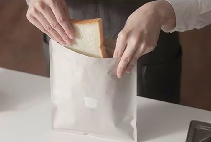 <p>アルミをはさんだ3層構造になっていて、ニオイ移りや乾燥を防いでくれるパン保存袋。ベージュの袋に食パンのイラストが描かれたデザイン性の高さもポイント。1枚の袋に、5～6枚切り食パンが3枚収められる収納力にも注目です。</p>
