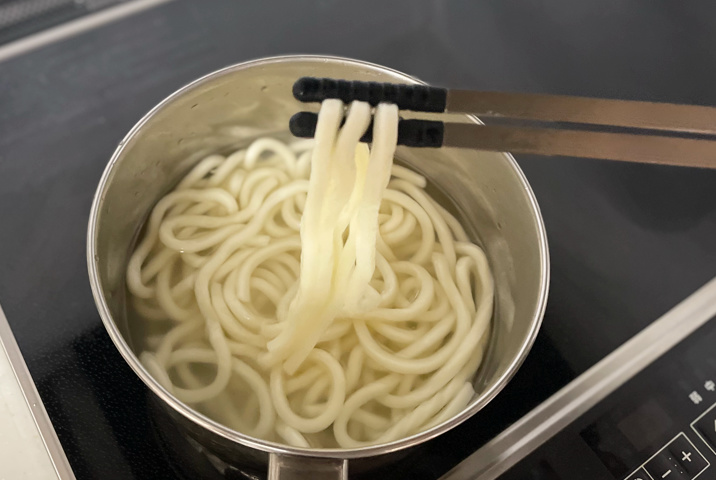 「かくはんしやすい細菜箸」で鍋からうどんを引き上げる