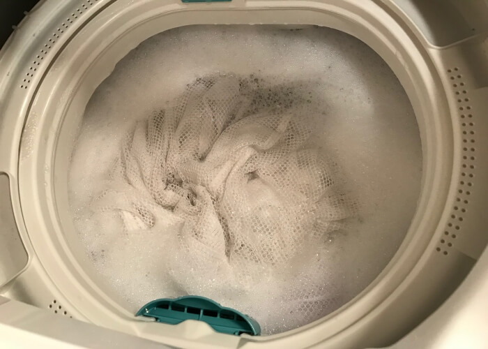 洗濯機にカーテンを入れて洗っているところ